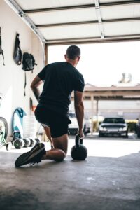 man in black t-shirt and black shorts standing on black and white basketball hoop