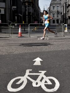 woman running on gray concrete pavement taken at daytime