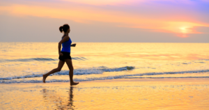 Woman running on a beach at sunset
