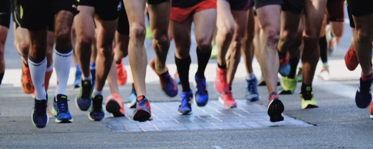 people running on gray asphalt road during daytime training for a marathon