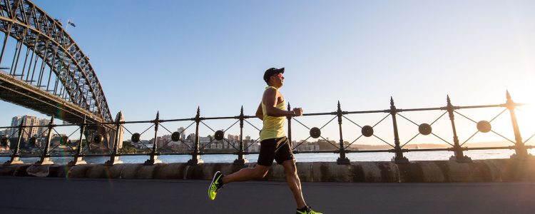 man in yellow tank top running near shore marathon training
